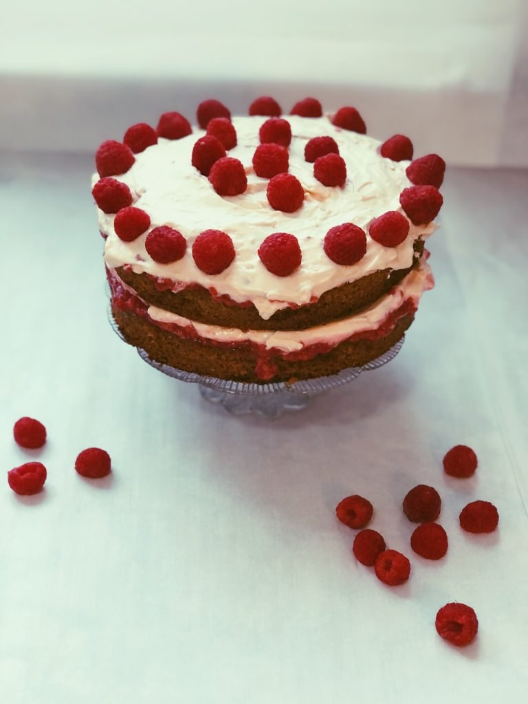 grain free raspberry-infused cake with raspberry jam and honey meringue frosting